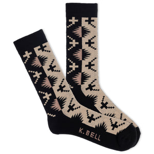 A pair of K.Bell men's crew socks with a desert-inspired print in black and beige colors, featuring a geometric pattern.