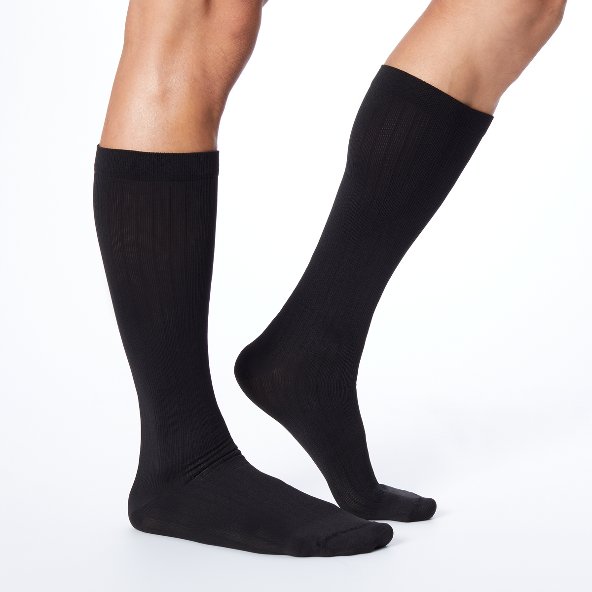 Side profile of a man wearing Dr. Scholl's black knee high compression socks.