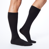 Side profile of a man wearing Dr. Scholl's black knee high compression socks. thumbnail