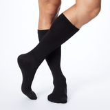 Front profile of a man wearing Dr. Scholl's black knee high compression socks.