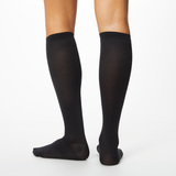 Woman wearing black Dr. Scholl's knee high socks