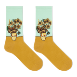 A pair of crew socks featuring a classic Van Gogh-inspired sunflower and chrysanthemum floral print on the upper half, with a solid mustard yellow lower half and a pale mint green cuff.