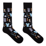 A pair of black crew socks with a medical-themed pattern featuring light blue scrubs, stethoscopes, X-ray images, pills, and hands, displayed against a solid white background.