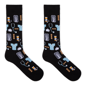 A pair of black crew socks with a medical-themed pattern featuring light blue scrubs, stethoscopes, X-ray images, pills, and hands, displayed against a solid white background.