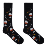 A pair of black crew socks with a repeating pattern of cognac whiskey glasses, cigars, and smoking pipes, displayed flat against a solid white background.