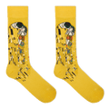A pair of yellow crew socks featuring a stylized print of Gustav Klimt's 'The Kiss' on the upper leg, displayed against a solid white background.