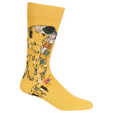 A single mustard yellow crew sock featuring a stylized graphic print of Gustav Klimt's 'The Kiss' on the leg, shown against a plain white background.
