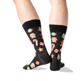 A pair of black crew socks with a colorful Christmas gingerbread pattern, worn on a person's legs against a white background. thumbnail