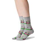 A pair of gray crew socks with a colorful golf course and golf cart pattern, worn on a person's feet against a white background. thumbnail
