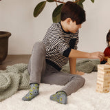 Child playing with wooden blocks on a carpeted floor thumbnail