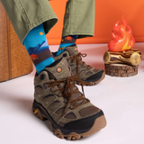 Person wearing hiking boots and colorful socks with a scenic design, against an orange and white background.
