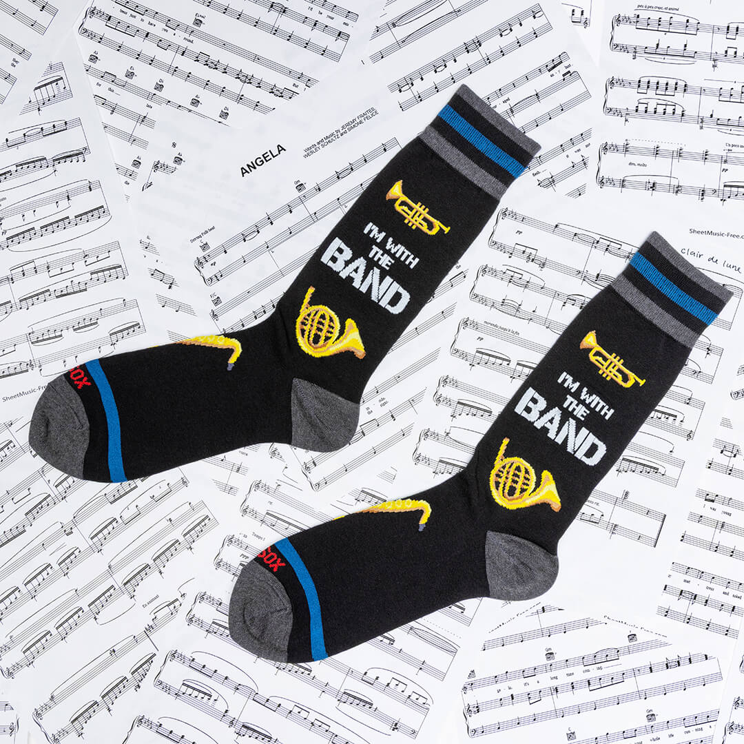 Two socks with musical design and text on a sheet music background