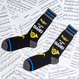 Two socks with band-themed design on a sheet of music.