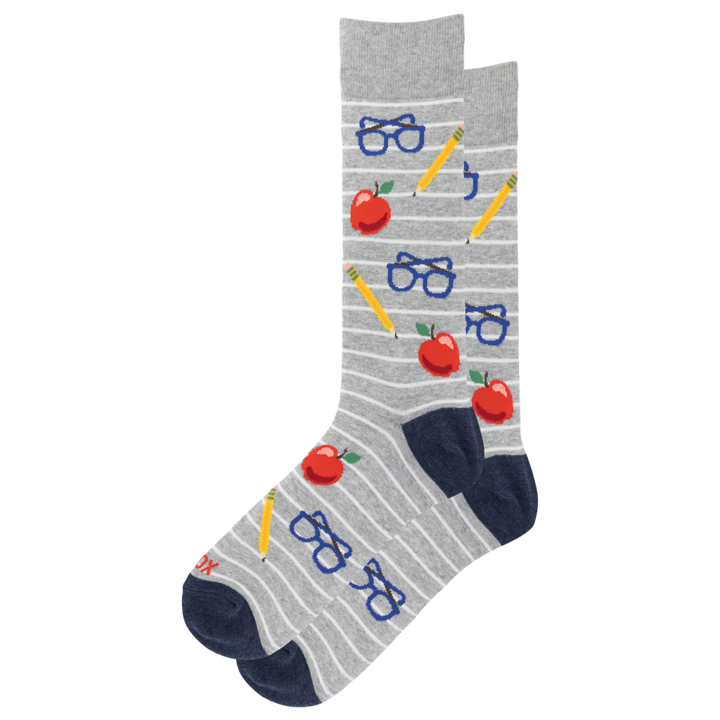 A pair of gray crew socks with thin white horizontal stripes, featuring a playful school-themed pattern of red apples, blue glasses, yellow pencils, and navy blue heels and toes.