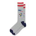 A pair of heather gray crew socks with red stripes at the top, navy blue heels and toes, and a colorful graphic of a skier with the text 'SKI you later' on the front sock, shown against a plain white background.