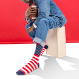 Person wearing American flag socks sitting on a box against a red background thumbnail