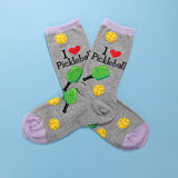 Gray socks with pickleball designs and text on a blue background thumbnail