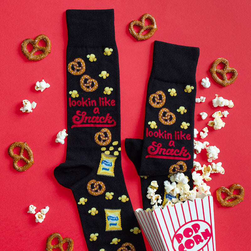 Black socks with snack-themed design on a red background with popcorn and pretzels.
