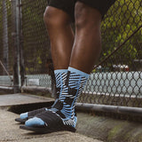 Person wearing black and blue patterned socks with a blurred background