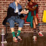 Two people sitting on a bench with trophies, wearing colorful socks. thumbnail