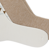 Two pairs of crew socks arranged diagonally on a white background, showing different colorways: one heathered tan pair and one white pair with a small brown and light blue argyle pattern. thumbnail