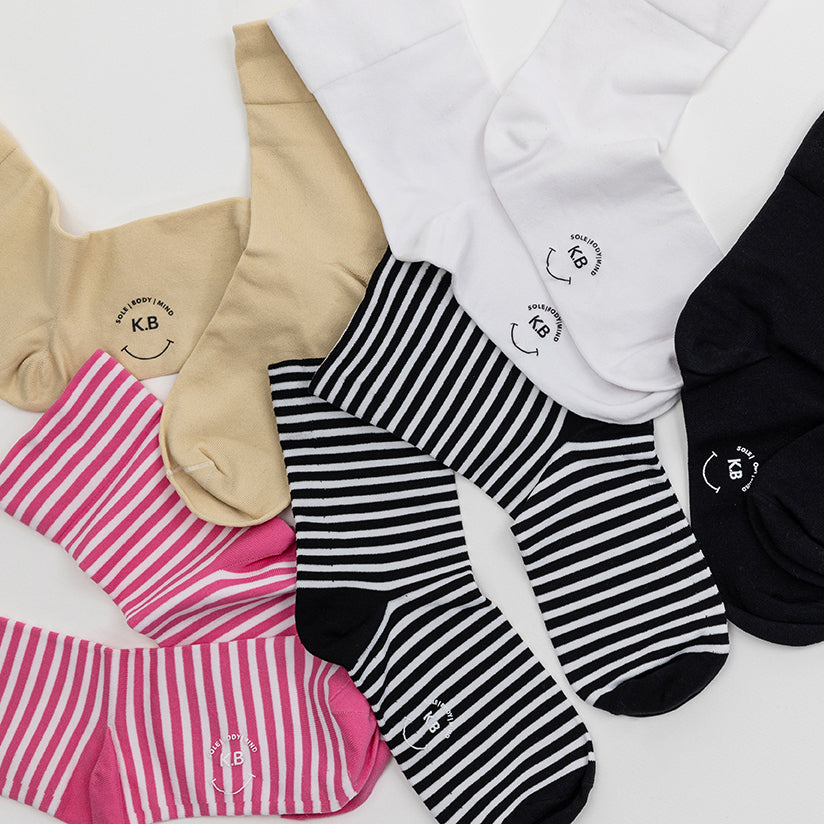 K.Bell striped and solid microfiber crew socks in various colors and patterns on a white background
