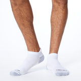 Front profile of a person wearing white MERRELL socks with black and gray accents on the heel and toe.