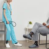 Person in light blue scrubs with a stethoscope, standing next to another person in gray pants and black Crocs. thumbnail