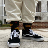 Child wearing sneakers, cream sweats and HOTSOX socks with taco and pepper designs. thumbnail