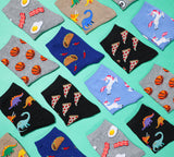 Collection of colorful kids' novelty socks with various patterns on a teal background thumbnail