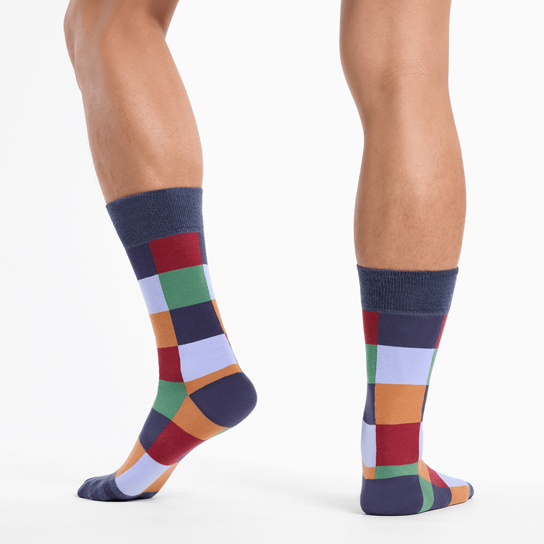 Colorful checkered socks worn by a person on a white background