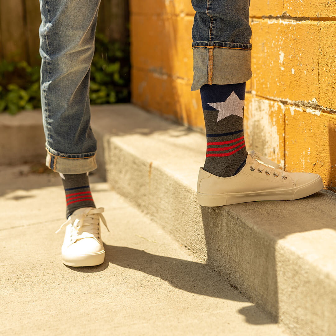 Person wearing star-patterned socks with a yellow wall in the background