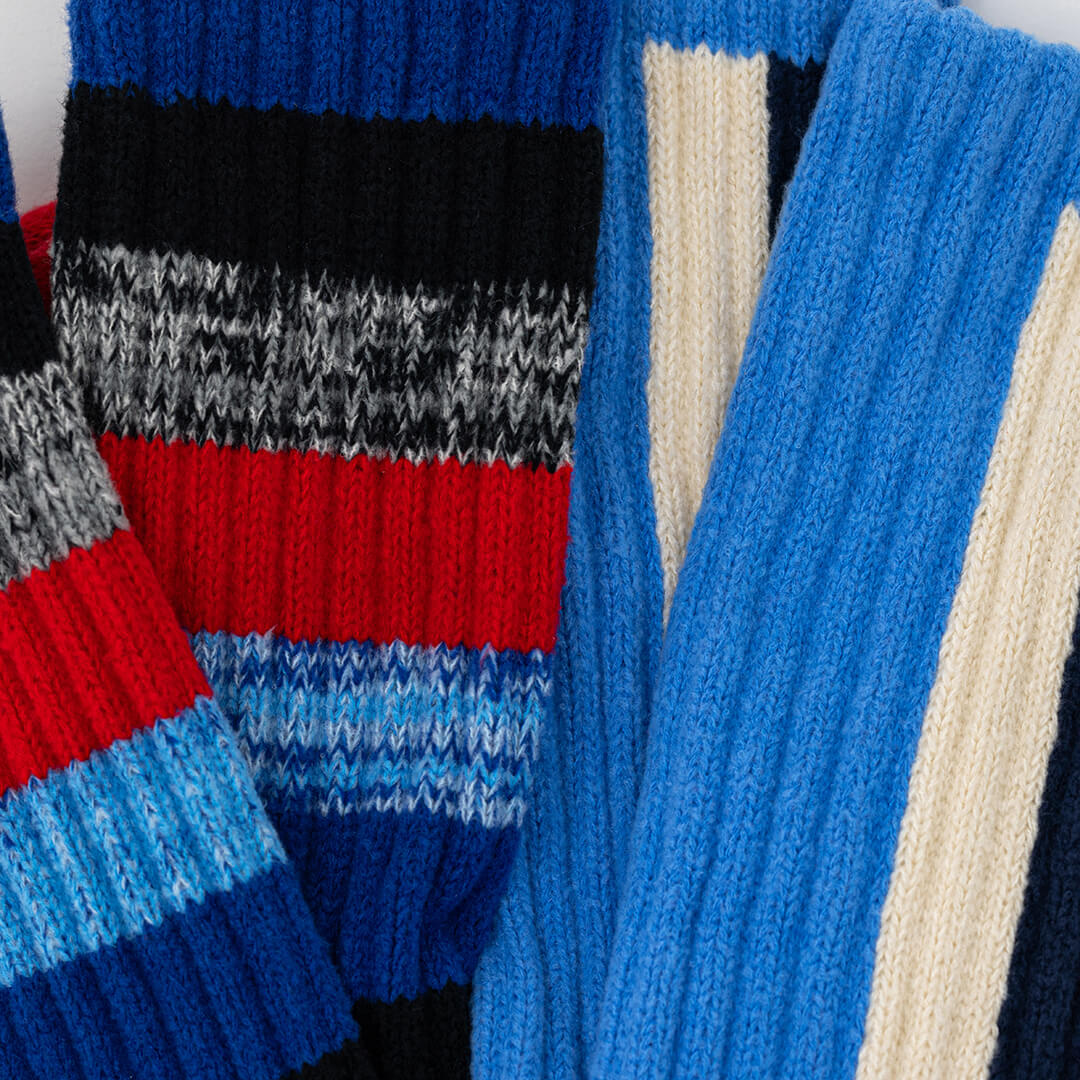 Close-up of a colorful striped sweater with blue, red, and gray patterns.