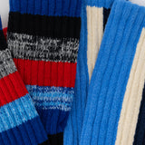 Close-up of a colorful striped sweater with blue, red, and gray patterns.