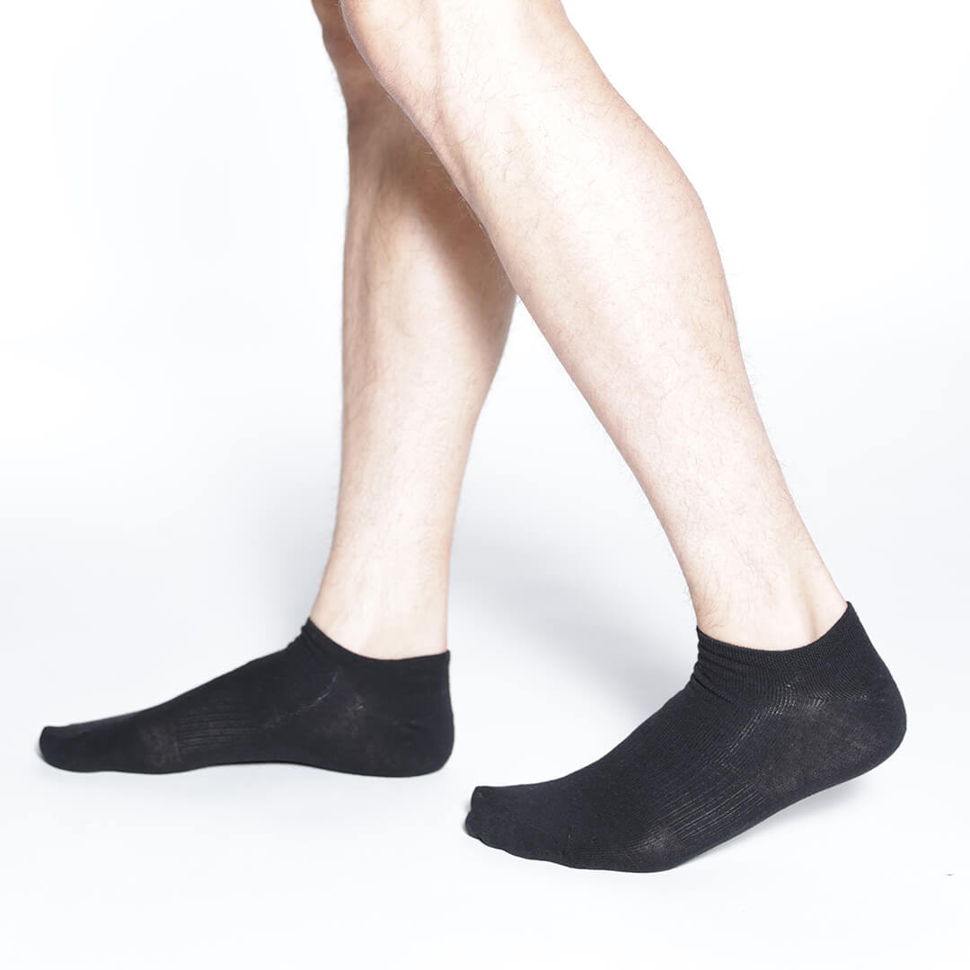 Close-up of a man wearing black socks on a light background