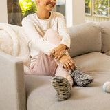 Person sitting on a couch wearing cozy slippers in a home setting thumbnail