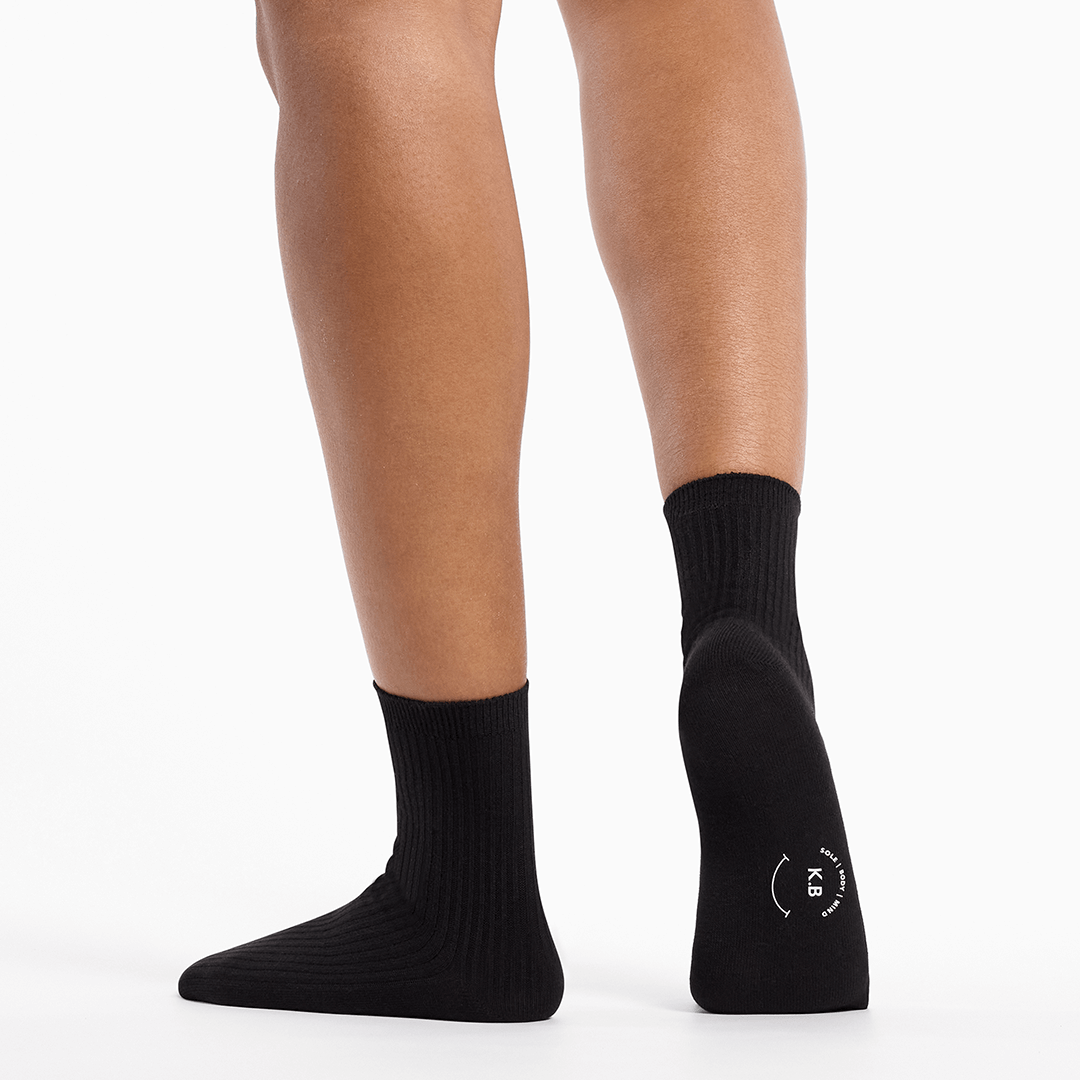 Black socks worn by a person on a white background