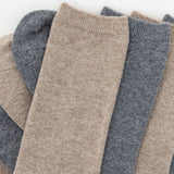 Stack of beige and gray socks on a white background thumbnail