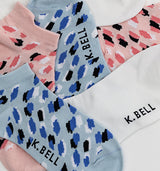 Colorful patterned socks with 'K. Bell' branding on a white background