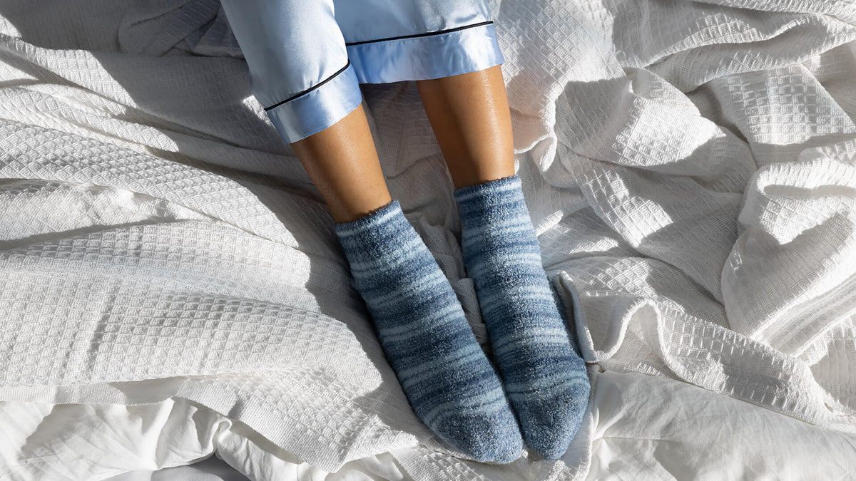 Person wearing blue and white striped socks on a beige surface