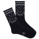 A pair of K.Bell women's roll-top crew socks with a winter sparkle design, featuring star patterns on a black background.